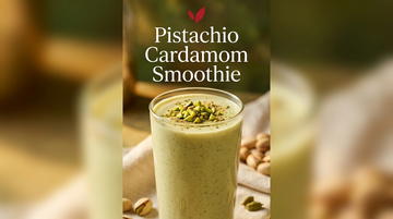 Pistachio Cardamom Smoothie recipe cover - a tall clear glass of pale green pistachio smoothie garnished with chopped pistachios and cardamom