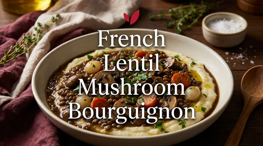French Lentil and Mushroom Bourguignon - a dark glossy plant-based stew of French green lentils, cremini mushrooms, pearl onions and carrots in a rich herb-scented sauce, served over mashed potatoes and garnished with fresh parsley