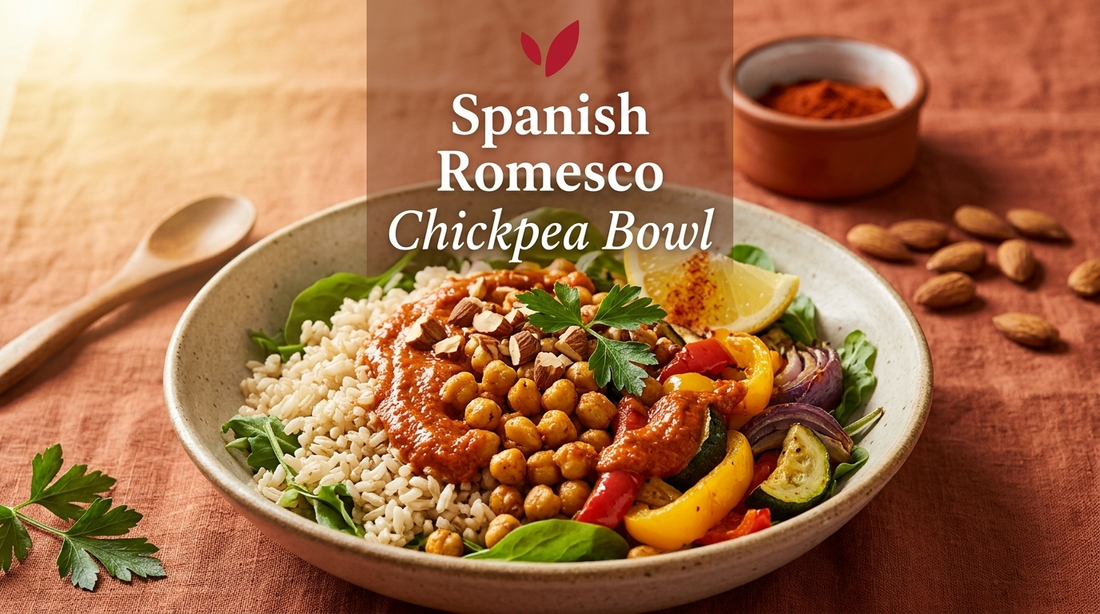 Spanish Romesco Chickpea Bowl - roasted chickpeas and colorful bell peppers over brown rice and baby greens topped with rich red-orange almond romesco sauce, garnished with parsley, toasted almonds and a lemon wedge